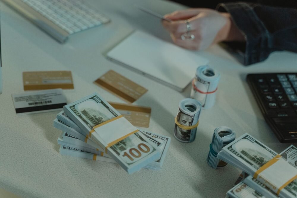 Žmogus analizuoja nedidelės paskolos sutartį, skaičiuotuvą ir finansinius dokumentus.